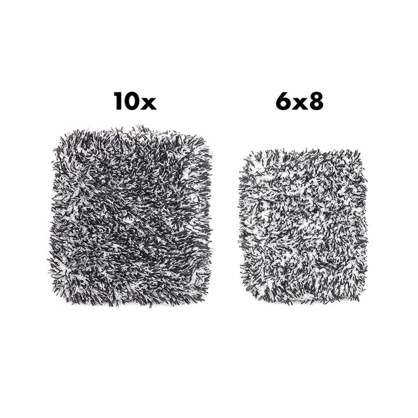 Two similar sized black and white microfiber wash pads on a white background