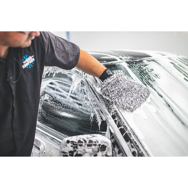 black and white wash mitt being used on a windowshield