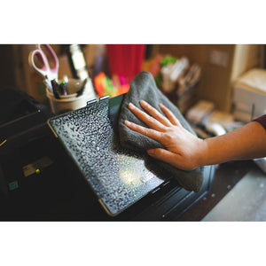 A dark grey TRC Towel wiping down the screen of a POS machine.