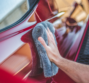 Using a grey Eagle Edgeless 600 towel to detail the exterior of a red Ford GT