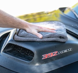 Using a 20"x24" Double Twistress microfiber towel from The Rag Company to dry the hood cowl of a black Dodge Challenger with a 392 hemi engine. The towels have a ButerSoft scratchless suede edge that is safe on paint, trim, and glass