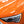 The headlight of an orange car.