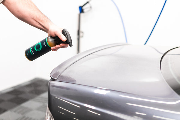 A closeup of a person spraying the side of their car with Armour Adapt.