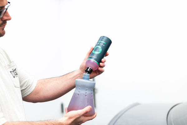 A person pouring Armour Decon Soap into a foam cannon.