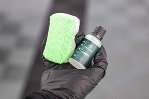 Armour Detail Supply Glass Coating 30 ml bottle and Sponge being held in a persons gloved hand. 