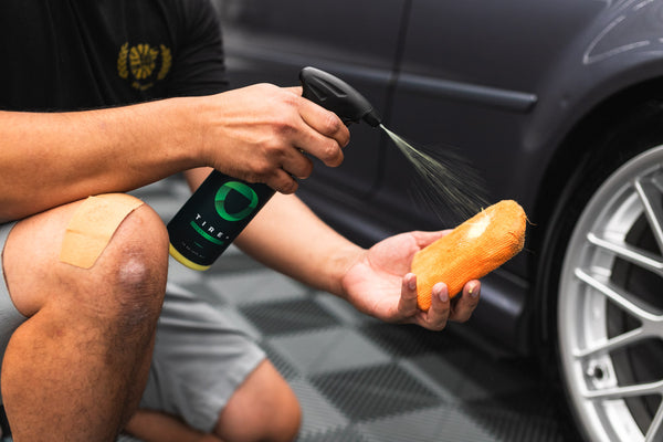 A person spraying an orange sponge with Armour Tire+.