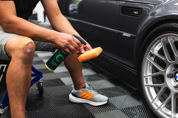 A person spraying Armour Tire+ on an orange sponge.