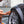 A closeup of a person cleaning a car tire with an orange sponge.