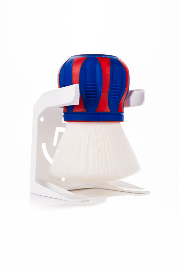 The red, white, and blue Detail Factory Curveball brush in it's holder on a white background in a 