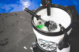 A Detail Factory Wheel brush in a bucket of foam.