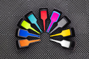 A person using a Detail Factory Wheel Face Brush all color variations on a grey background.