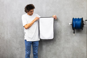 Person holding a white 16x24 dry me a river microfiber towel.
