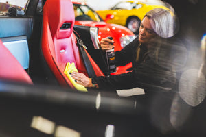Person cleaning car interior with a spray bottle of swift and yellow edgeless 300