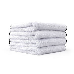 Four white Everest towels stack on top of one another on a white background.