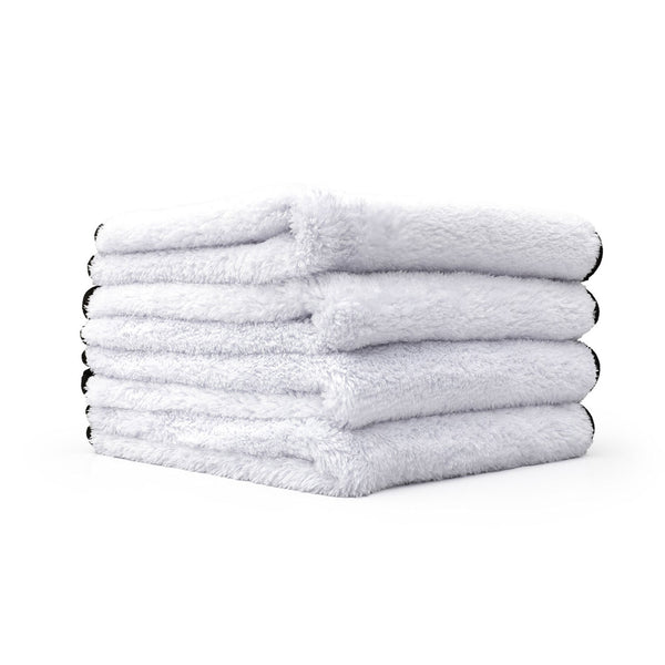 Four white Everest towels stack on top of one another on a white background.