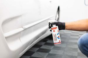 Gtechniq W6 Iron and Fallout Remover sprayed onto bottom part of white door panel of a Ford Explorer. 