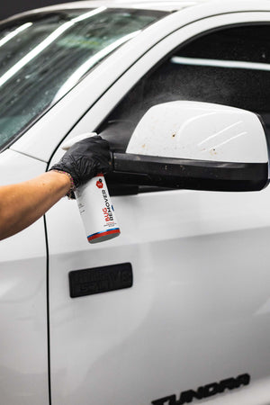 Gtechniq W8 Bug Remover being used on a white truck side mirror.