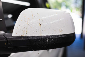 Gtechniq W8 Bug Remover being used on a white truck side mirror.