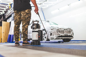 A person holding the sprayer connected to an iK e Foam Pro 12.