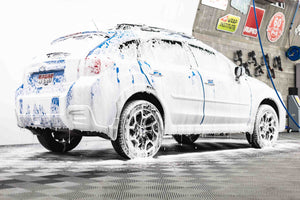 A blue car with soap on it.