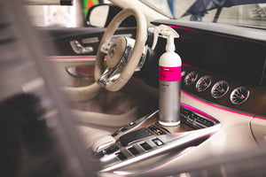 A spray bottle of Koch Chemie Fresh Up on the center console of a car.