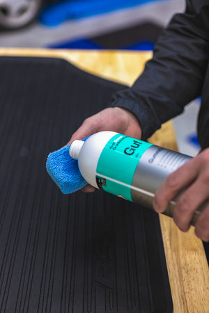 A person pouring Koch Chemie Gummi Fix on a blue sponge.