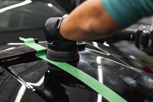 KochChemie Heavy Cut being used on a KochChemie Heavy Cut Pad v2 126mm attached to a polisher to show a before and after on the hood of a black car.