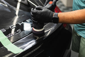 KochChemie Heavy Cut being used on a KochChemie Heavy Cut Pad v2 176mm attached to a polisher to show a before and after on a black car.