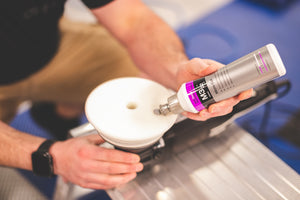 A person pouring Koch Chemie Micro Cut onto a white polishing pad.