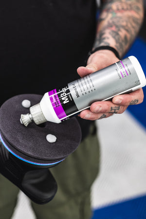 KochChemie Micro Cut being poured onto a KochChemie Micro Cut Soft Foam Pad on a Rupes polisher.