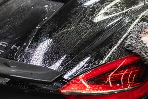 Close-up of a car's rear end with KochChemie NanoMagic Shampoo.