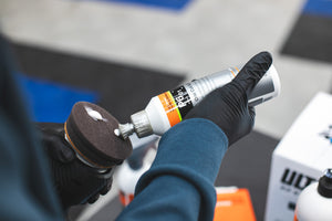KochChemie One Cut and Finish being poured onto a KochChemie One Cut and Finish pad on a Rupes Polisher.