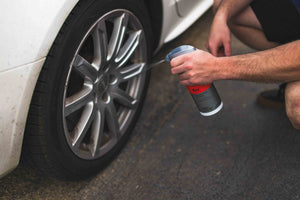 Person spraying KochChemie Reactive Rust Remover on a car tire rim.