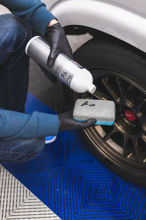 Person cleaning a car's tire with KochChemie Tire Glaze.