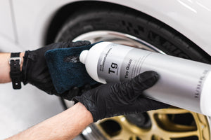 Person cleaning a car's tire with KochChemie Tire Glaze and a black appolicator.