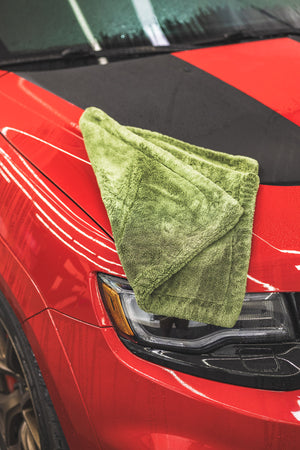 Green M22 laying folded on top of a red car.