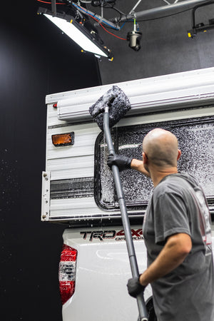 Mitt on a Stick being used to scrub off a camper.