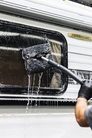 Mitt on a Stick being used to scrub off top of a camper.