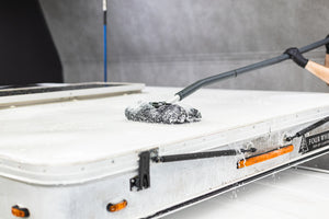 Mitt on a Stick being used to scrub off top of a camper.