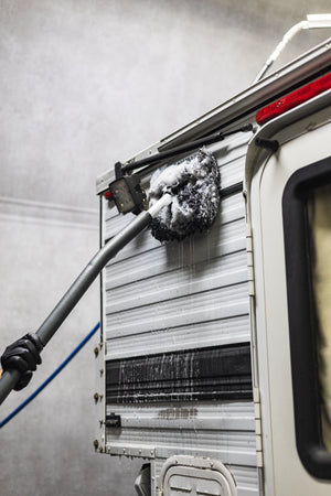 Mitt on a Stick being used to scrub off side of a camper.