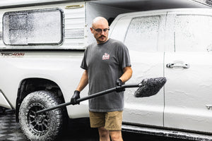 A person holding a mitt on a stick.
