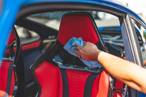 Person cleaning a red car seat with a blue edgeless 300.