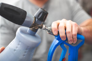 A close up of a person holding a sprayer.