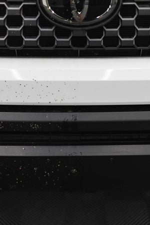 Close-up of a car grille with before and after of using P&S Bug Off.