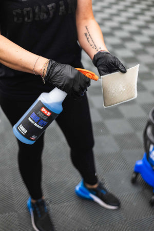 Person spraying a bottle of P&S Bug Off onto a Jersey Bug Scrubber.