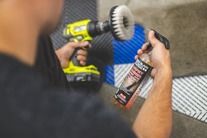 A person spraying a polisher with P and S Carpet Bomber.