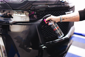 Person spraying P&S Inspiration Defender onto the bumper of a car.