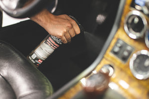 A person spraying the carpet in the front seat with P and S terminator.