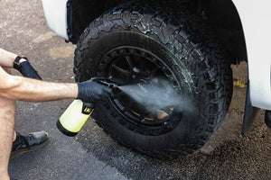 Person cleaning a tire with an iK Sprayer filled with P&S Undressed.
