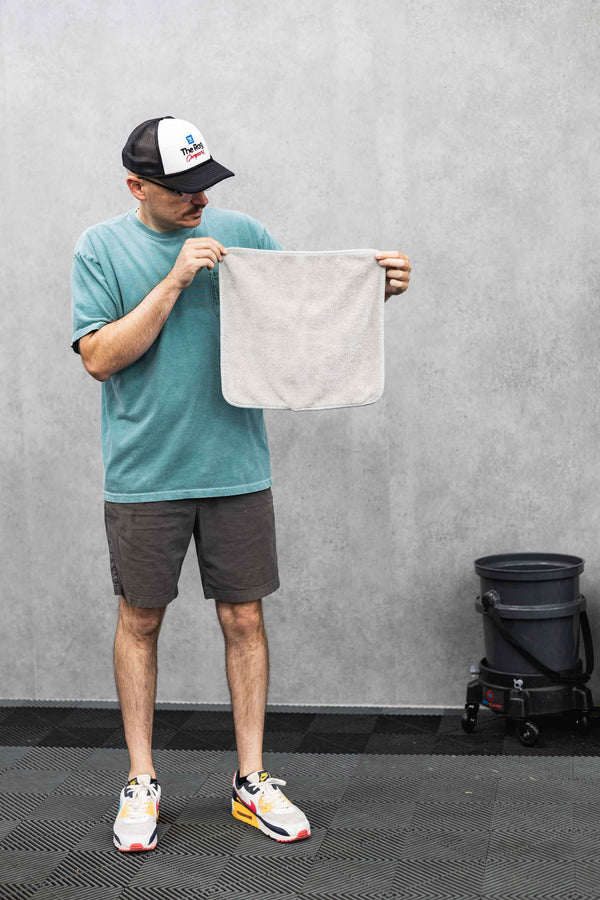 Person holding a grey FTW microfiber towel